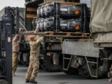 Soldati occidentali caricano armamenti su camion militari