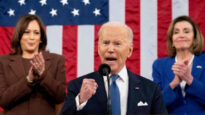 Foto d'archivio. Il presidente Biden durante un discorso. Alle sue spalle Kamala Harris e Nancy Pelosi applaudono