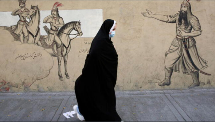 Donna con velo passa di fronte ad un murale