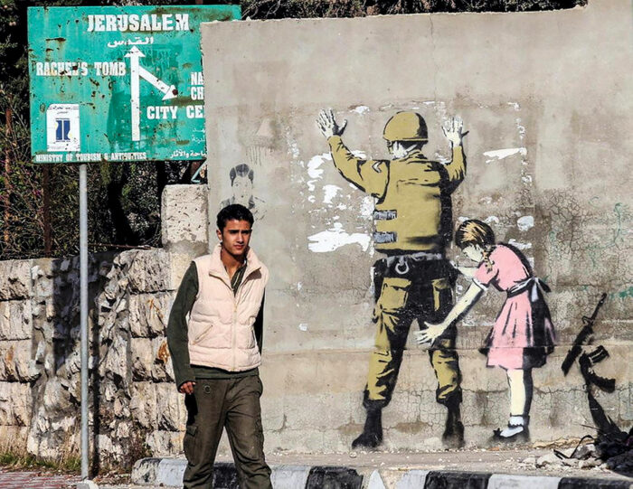 Un murale di Banski in palestina. Israele: le trattative di governo e le bombe a Gerusalemme