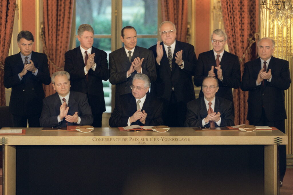 Felipe González, Bill Clinton, Jacques Chirac, Helmut Kohl, John Major e Viktor Chernomyrdin osservano la firma dell'accordo di Dayton da parte di Slobodan Milošević (Serbia), Franjo Tuđman (Croazia) e Alija Izetbegović (Bosnia Erzegovina).