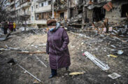 Anziana signora cammina tra i resti si un bombardamento in una città. Ucraina: nessuno spazio alla diplomazia