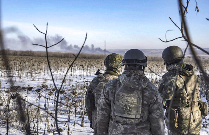 Militari osservano il fumo degli incendi a Soledar